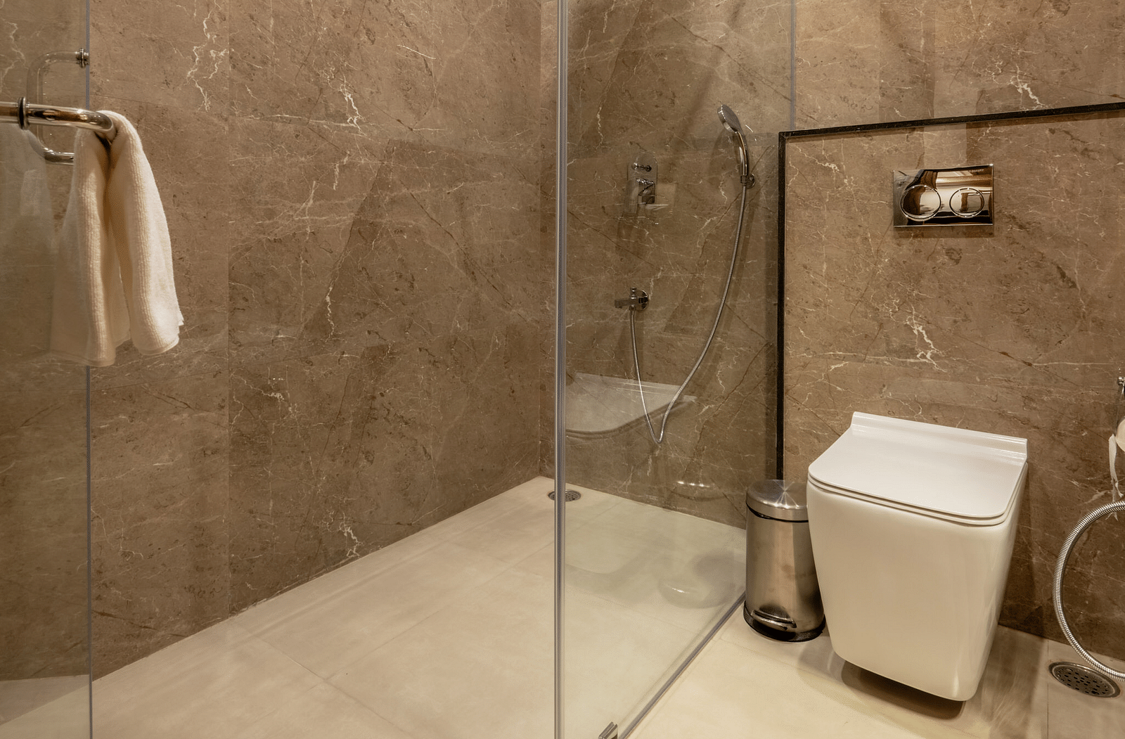 A washroom with the shower area, a toilet seat, and other toiletries - Brij Castle, Jaipur
