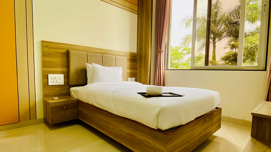 A bright hotel room with a large bed and a window offering outdoor views at Lotus Leaf Boutique Hotel.