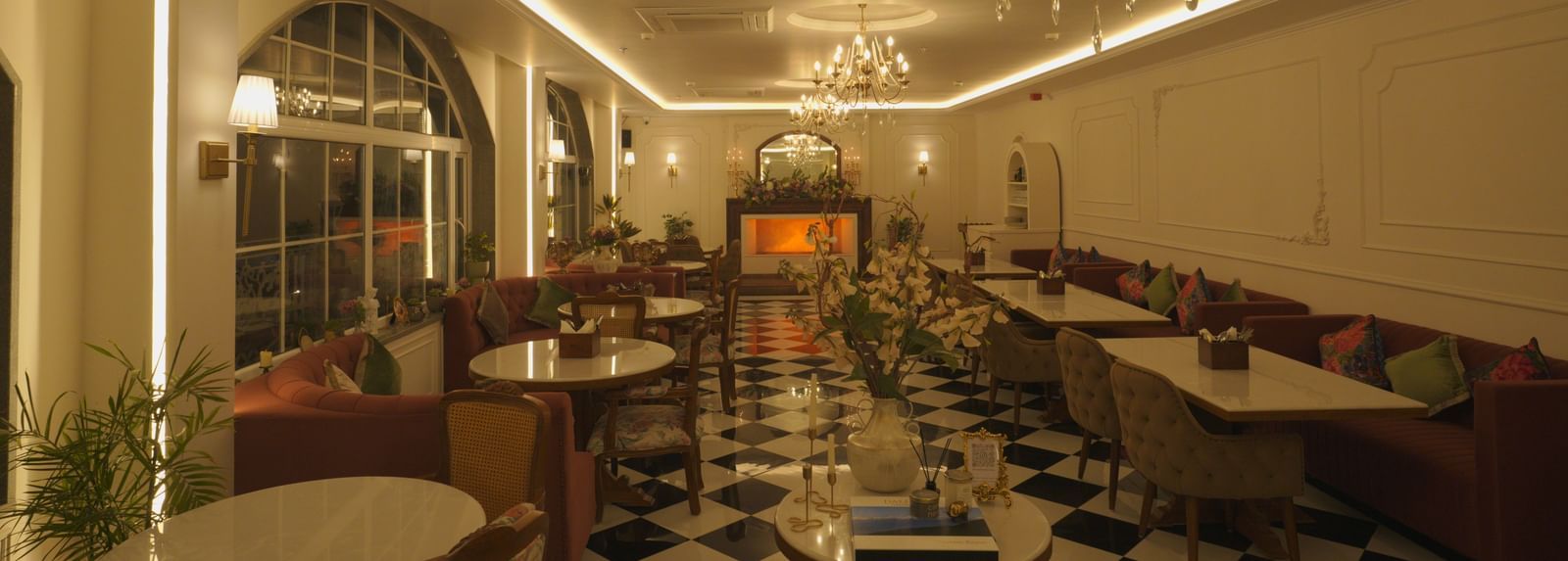 Classy dining area with black-and-white flooring, chandeliers, and booth seating - Mayfair Cafe & Suites, Dalhousie