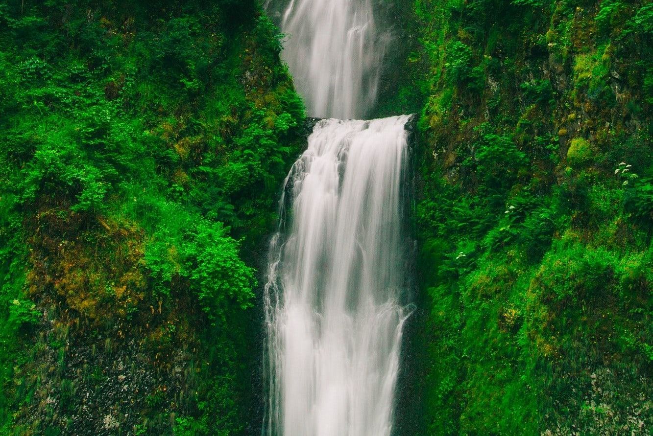 a shot of a waterfall cascading through the mountain 