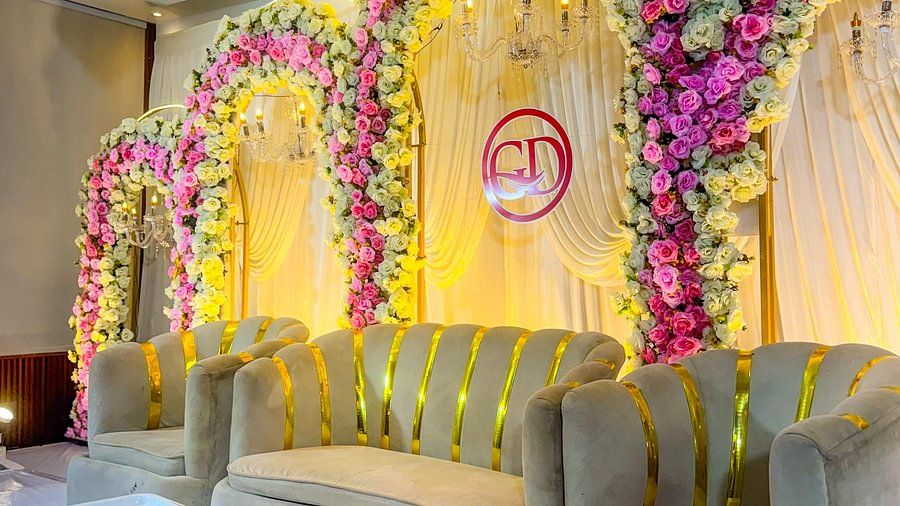 Stage with floral arches at Silver Sand Sea Princess Beach Resort, Port Blair, featuring curtains, table and three big sofas.