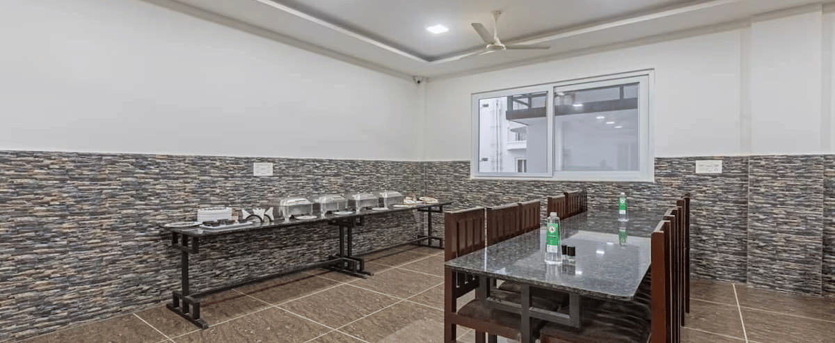 Simple indoor dining setup with tiled flooring and buffet corner, offering a clean and casual dining experience at Siri Ambari Resorts and Spa.