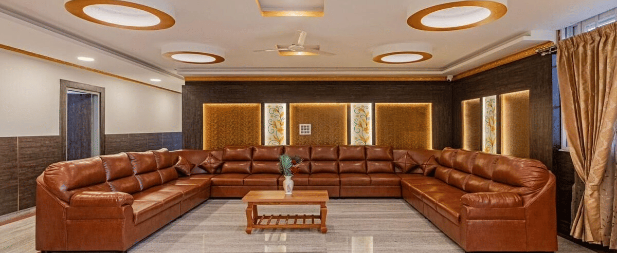 Luxurious lounge space with brown leather sofas, circular ceiling lights at Siri Ambari Resorts and Spa.