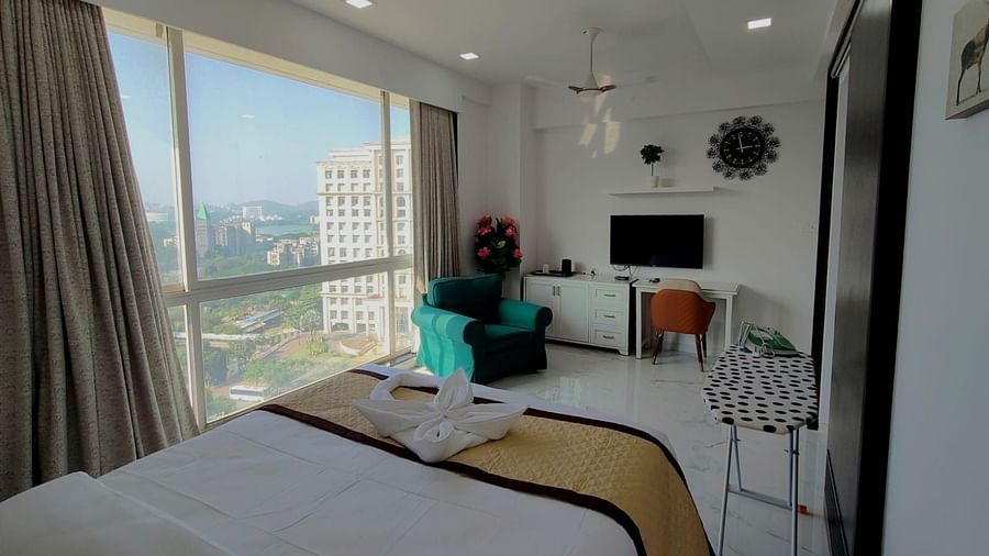 suite room at Maxxvalue Hotel, Chitranjan Tower, Powai with pristine white lines and wide windows offering city view and other room amenities