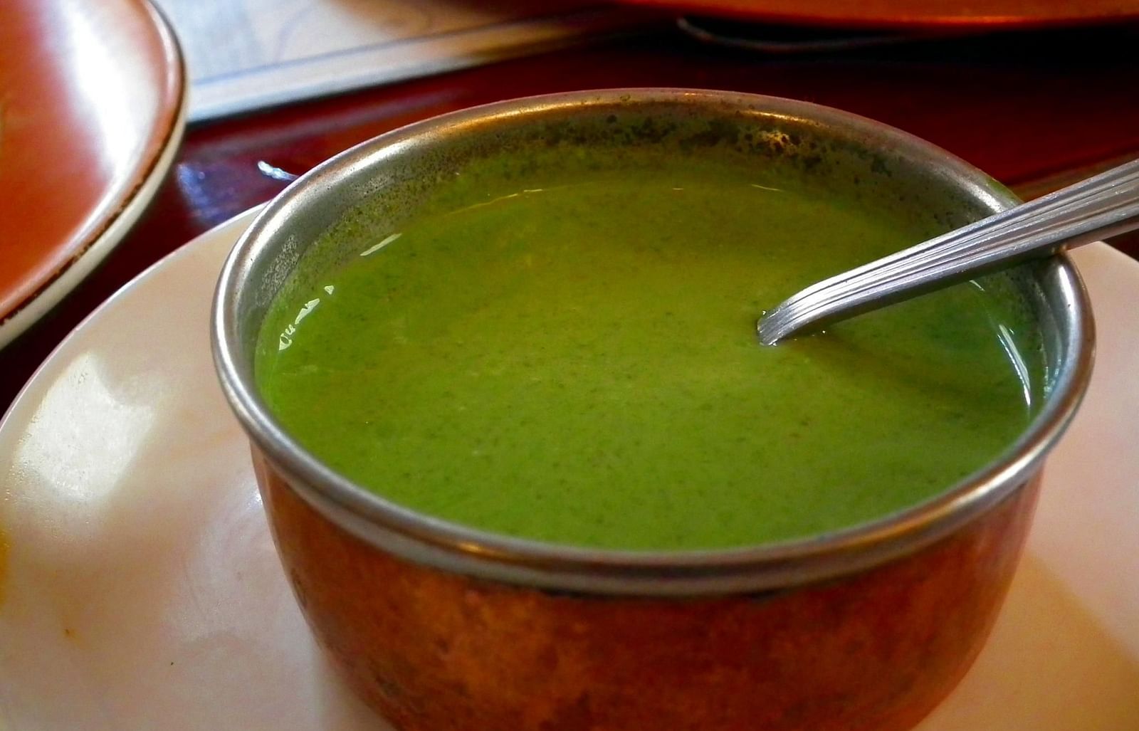 A close-up image featuring a bowl of soup placed on a plate.