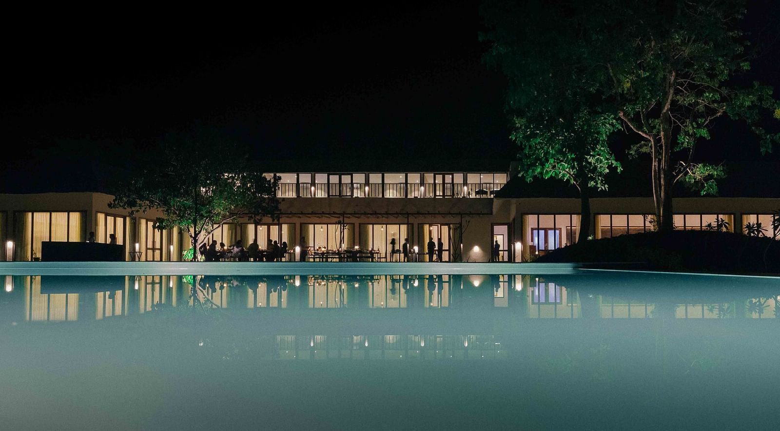 facade of Saraca Corbett with a pool in front of it during night time