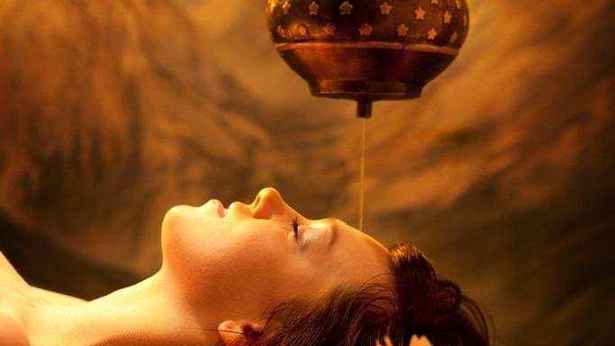 A person getting oil drip treatment at a spa