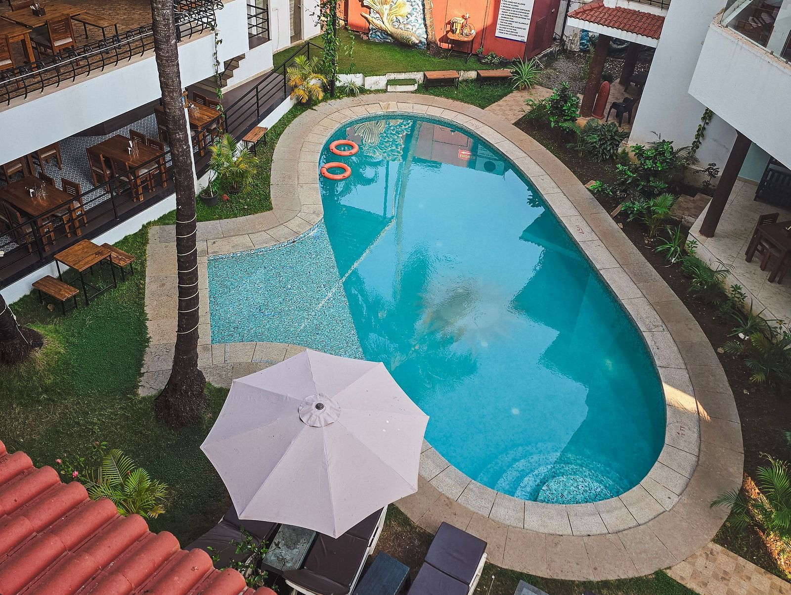 Top view of a narrow swimming pool bordered by loungers and umbrellas at The Verda de Miranda Resort.