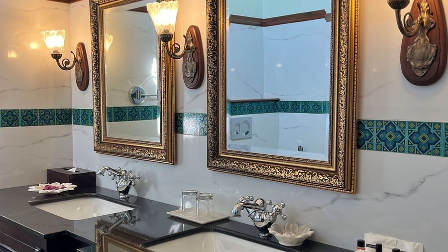 A traditional hotel bathroom with twin basins, a large mirror, and classic dark wood cabinetry - Khas Bagh, Jaipur.