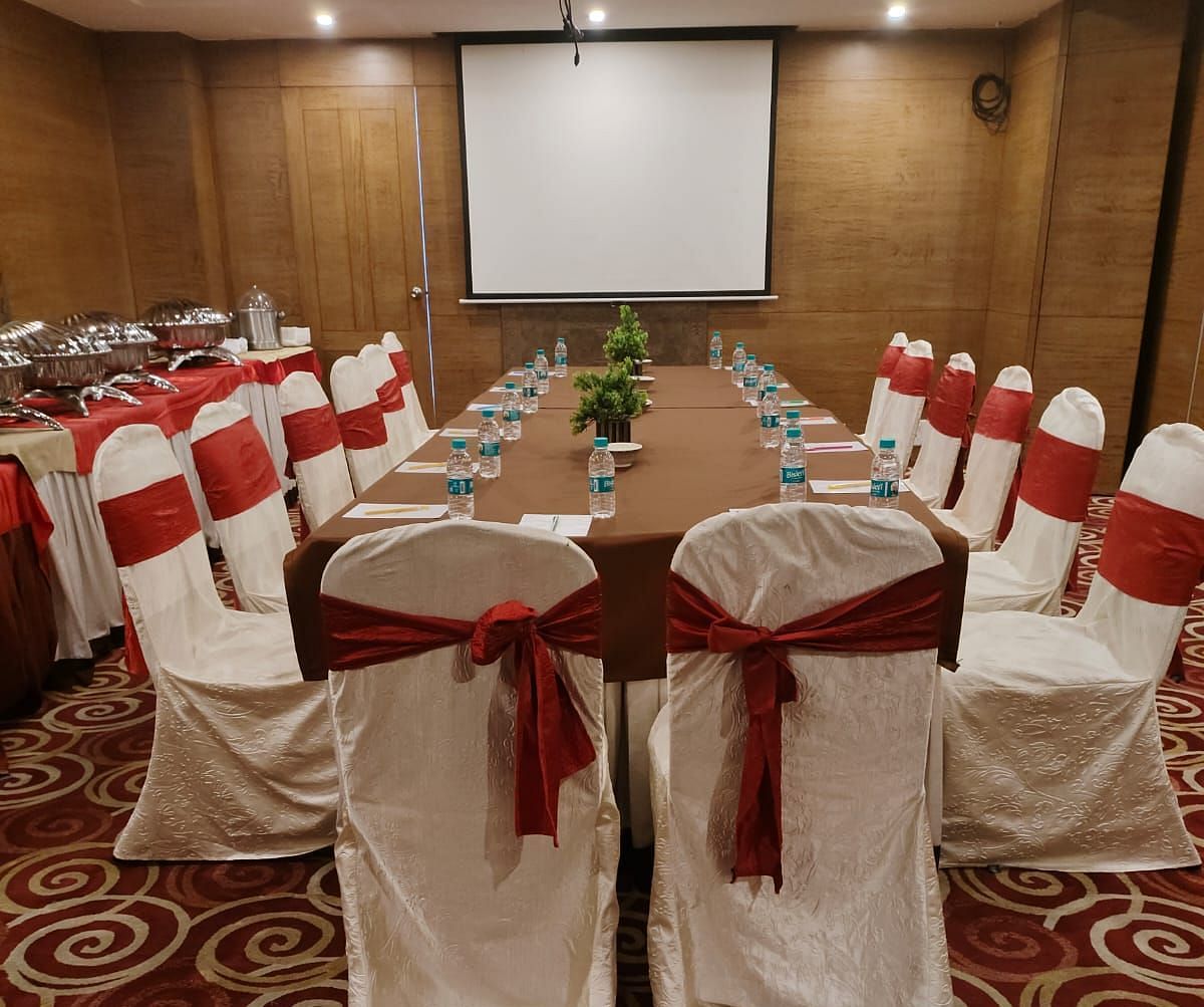 A conference room arranged for a meeting with red chairs and a patterned carpet - The President Hotel Jayanagar, Bangalore