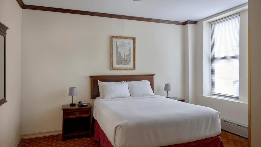 Room at Night Hotel Broadway showing a bed, framed wall art, and window near the corner.