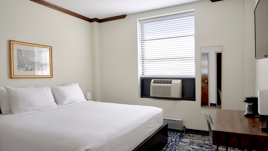 Guest room at Night Hotel Broadway with king bed, window, framed artwork, and carpet.