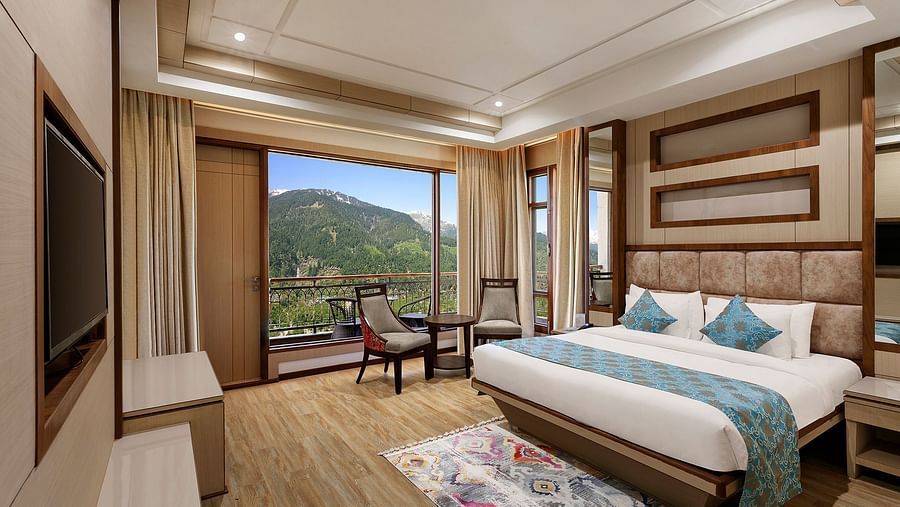 Suite with a king size bed and wooden flooring in Manali