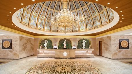 A reception area with a reception desk, receptionists and a giant chandelier - Kaldan Samudhra Palace