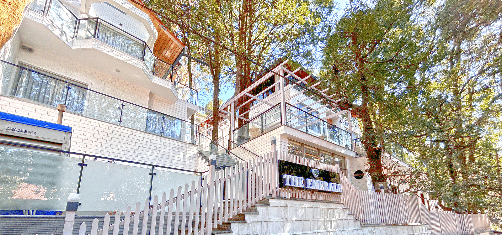 A facade image of DLS The Emerald, Nainital surrounded by tress and lush greenery