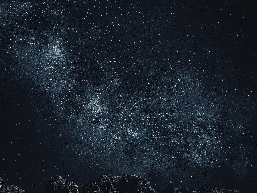 A view of a starry night sky with a faint glow on the horizon.