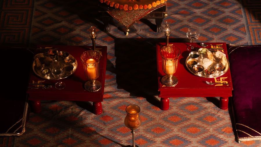 An overhead view of a richly decorated seating area at Fort Barli, featuring low tables with ornate details and plush cushions.