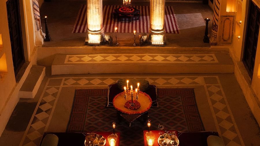 Ornate arches and warm lighting are reflected in a large mirror at Fort Barli, creating a layered and atmospheric interior view.