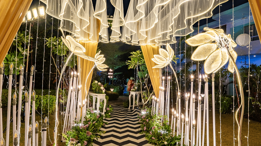 An intricate entrance pathway featuring a white scalloped arch and black and white zigzag flooring, beautifully lit for an event at Vedikant Resorts The Mallard Corbett.