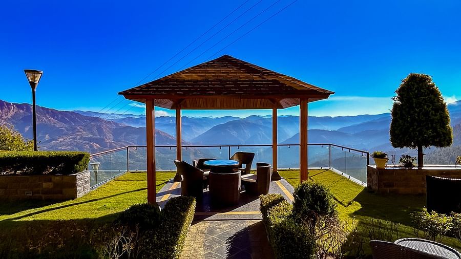 Stone pathway leading to a gazebo at Aranya Retreat, offering panoramic views of the serene Himalayan landscape