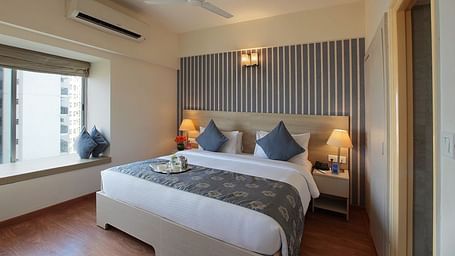 Deluxe room at Starlit Suites, Bangalore with a double bed during the day