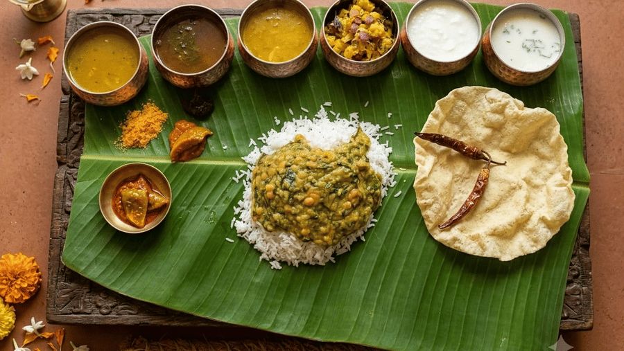 Traditional South Indian meal served on a banana leaf at Ni Central Park, Mysore, featuring rice, curries, papadum, and various side dishes in small metal bowls.