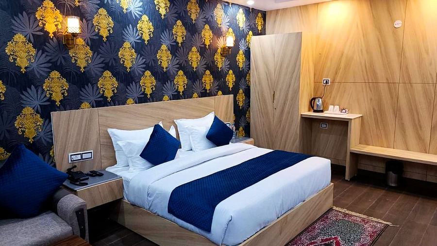 A Deluxe Room at DLS Nature Trinket Resort with a king size bed and a side table.