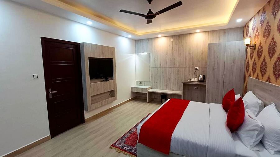 A Premium Room at DLS Nature Trinket Resort with a king size bed, a television, and a side table.