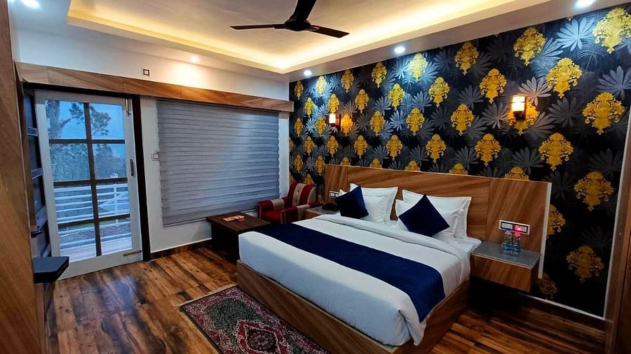 A Deluxe Room at DLS Nature Trinket Resort with a king size bed and a large window.