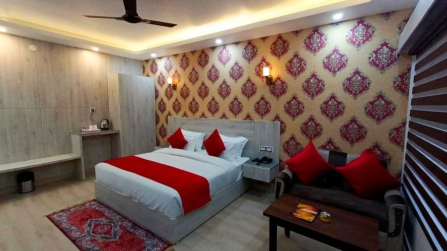 A Premium Room at DLS Nature Trinket Resort with a king size bed and a red couch.
