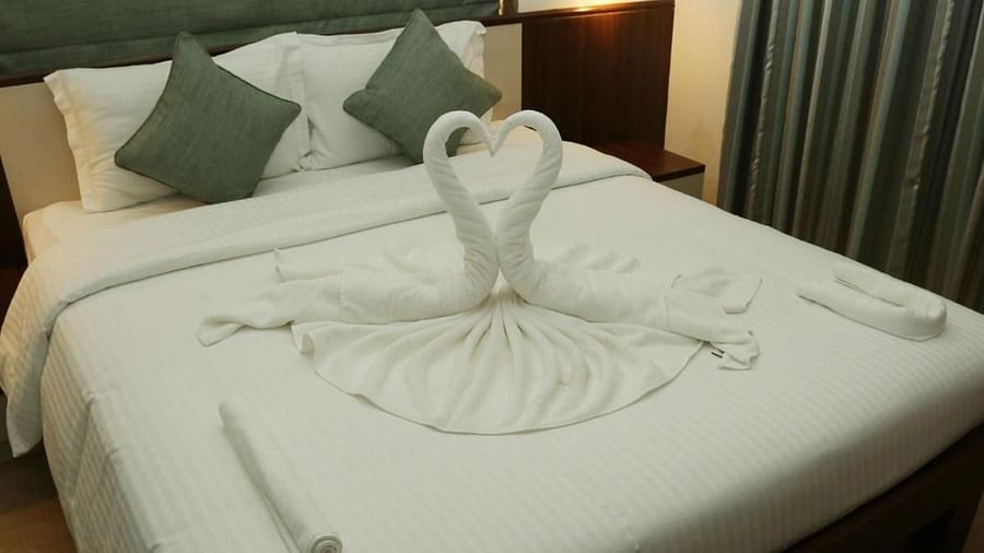 Close-up view of a spacious bed featuring two towel-folded swans as decoration at La Vida Studio Inn