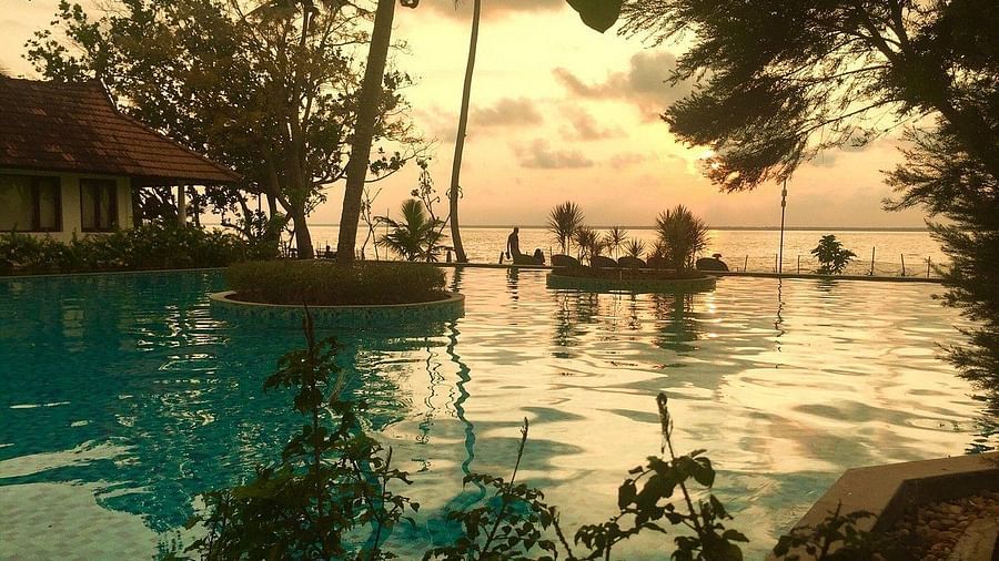 Pool with sunset in the background - Rhythm Kumarakom