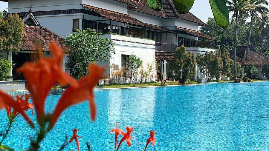 Pool with white building in the backdrop - Rhythm Kumarakom