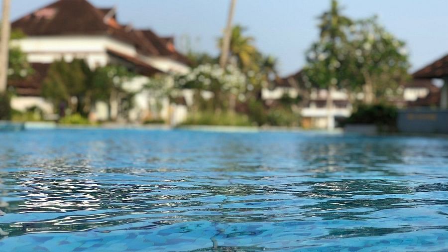 Swimming pool waters with blurred building in the background - Rhythm Kumarakom
