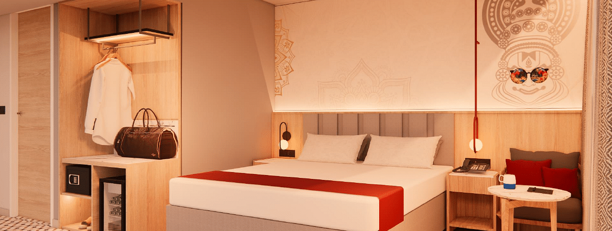 A spacious room with warm lighting, a bed, bedside tables, a couch, and a coffee table - TGI Oberon, Koramangala