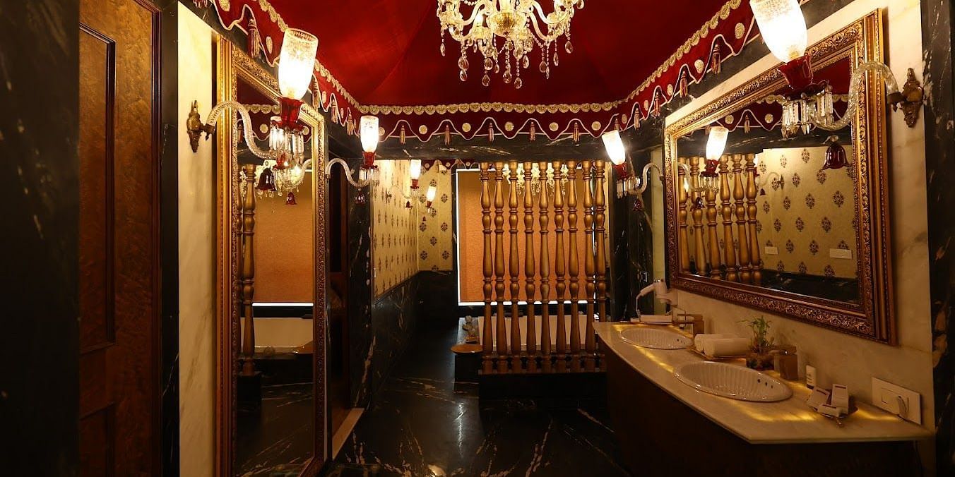 Image of a washroom with two sinks and a chandelier hanging from the ceiling at Rajasthali Resort & Spa Jaipur. 