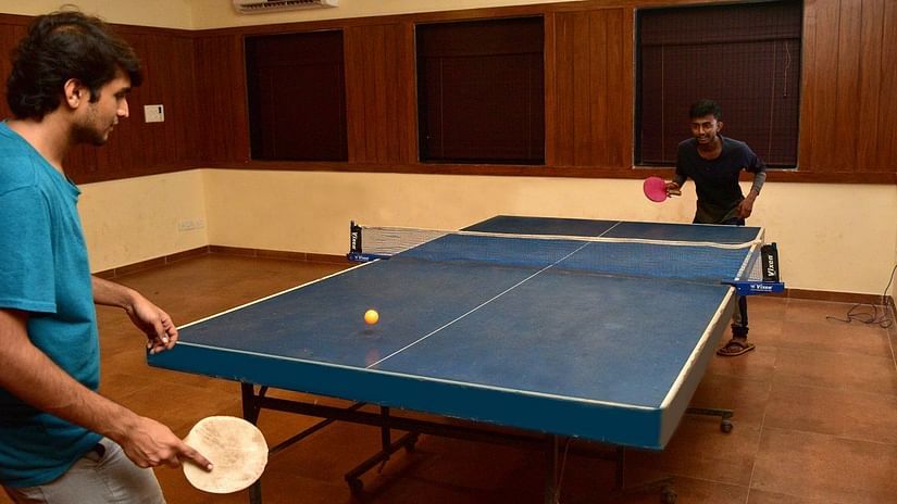 Two boys playing table tennis in a air conditioned room at Nature Trails Durshet