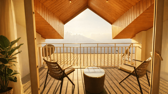 Room with balcony at Pride Premier Darjeeling featuring two chairs and a centre table facing towards the mountain view.