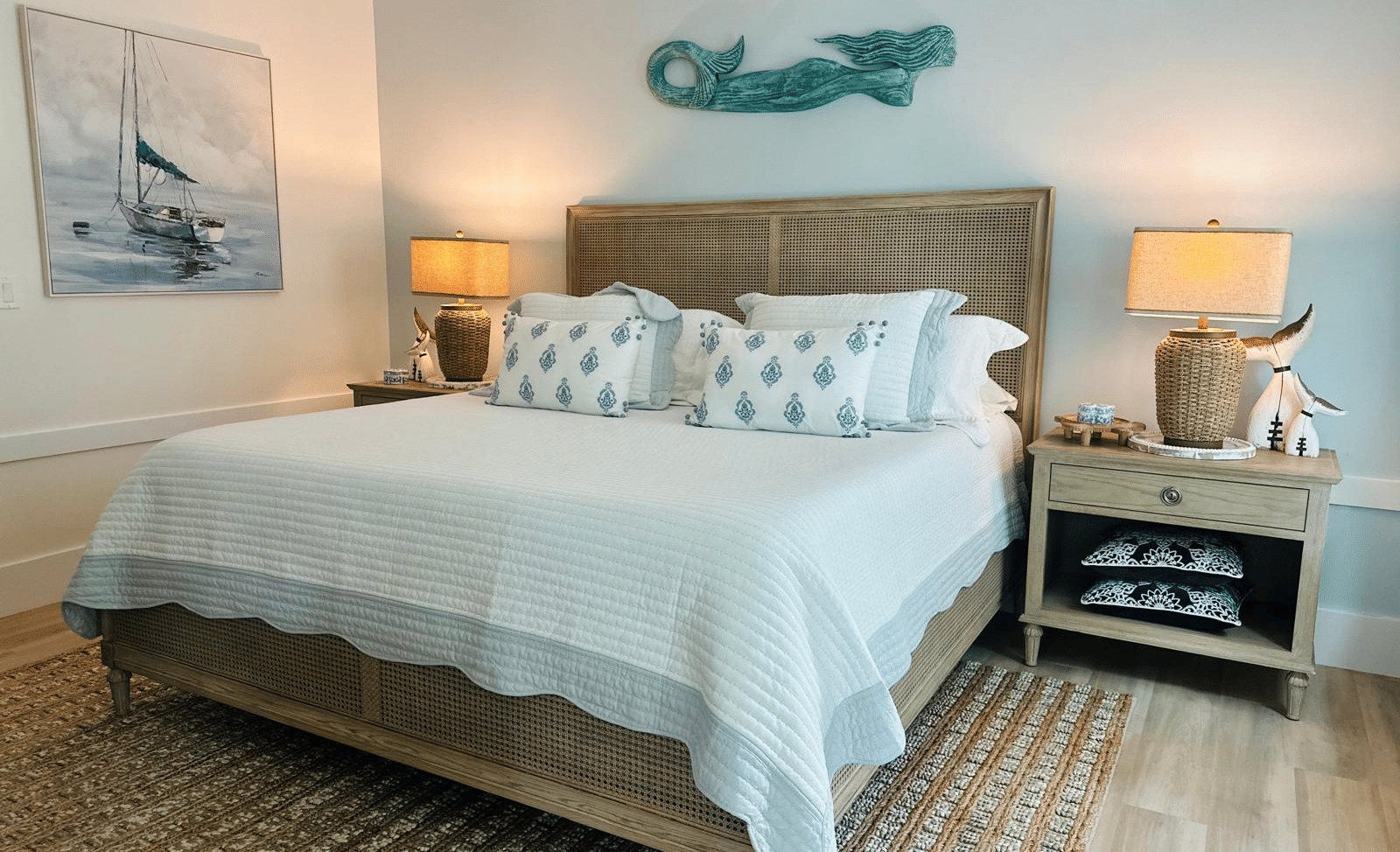 A view of a well made double bed, side tables with lamps and wooden flooring at Elbow Room Villa 7 in  Abaco inn 