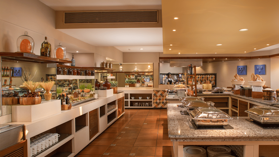 Modern buffet counter with food displays and warm lighting at Kenilworth Resort & Spa, Goa.