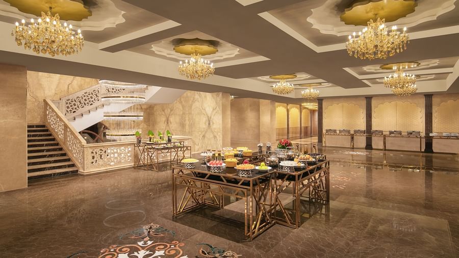 A banquet area with a table filled with foods placed under chandeliers – Kaldan Samudra Palace, one of the Best Banquet Halls in ECR