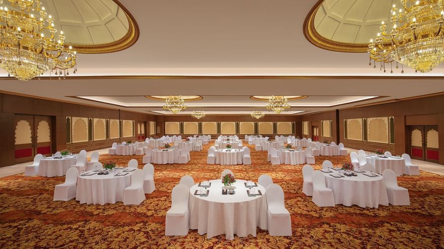 A banquet hall in Mahabalipuram with chandeliers, carpeted floors, and a cluster-type seating arrangement – Kaldan Samudra Palace, a Beautiful Wedding Venue ECR