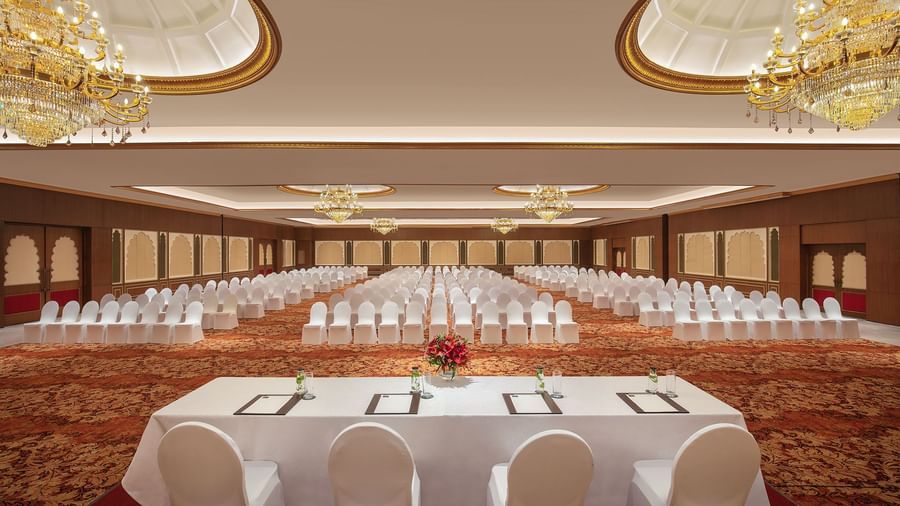 An image of a ballroom in Mahablipuram with chandeliers, carpeted floors and chairs arranged in a theatre style arrangement - Kaldan Samudhra Palace
