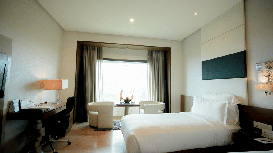 Spacious bedroom with minimalist furnishings and natural lighting – Narayani Heights Hotel & Resorts