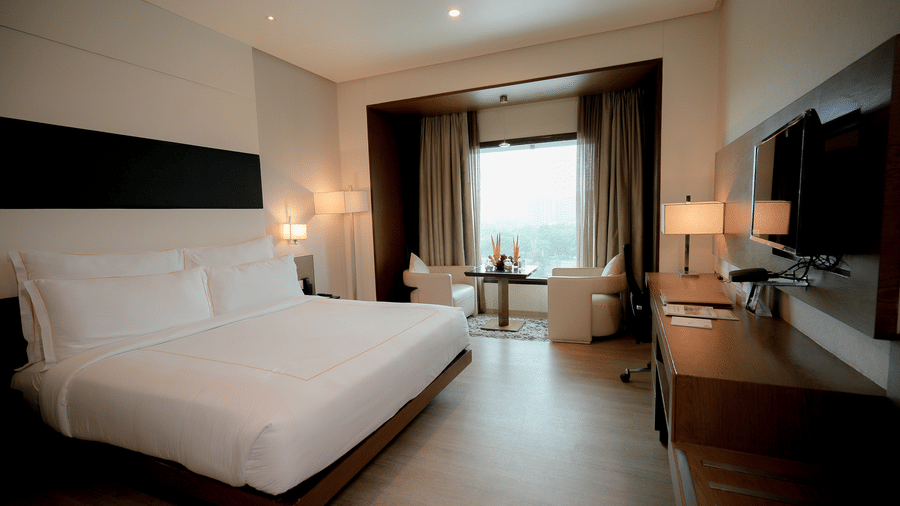 Spacious guest room with large bed, seating area, and a TV setup – Narayani Heights Hotel & Resorts
