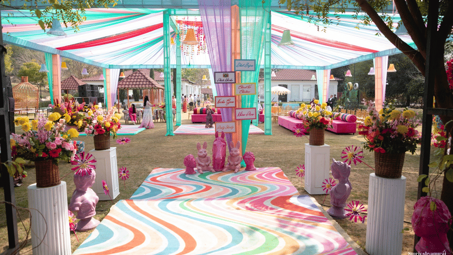An event setup at Valley By Grassfield, featuring flowing fabrics as ceiling decor, a patterned floor runner, and a stage area.