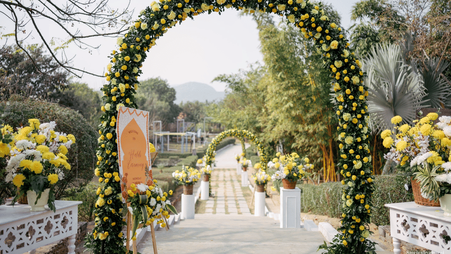 A large outdoor archway at Valley by Grassfield, made of foliage flowers, framing a pathway.