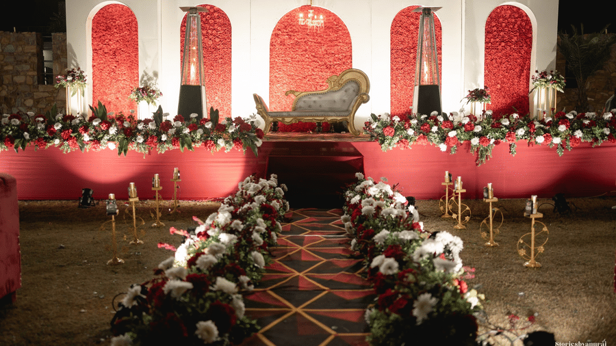 An ornate indoor stage at Valley by Grassfield, for a wedding, decorated in with a carpet leading to it.