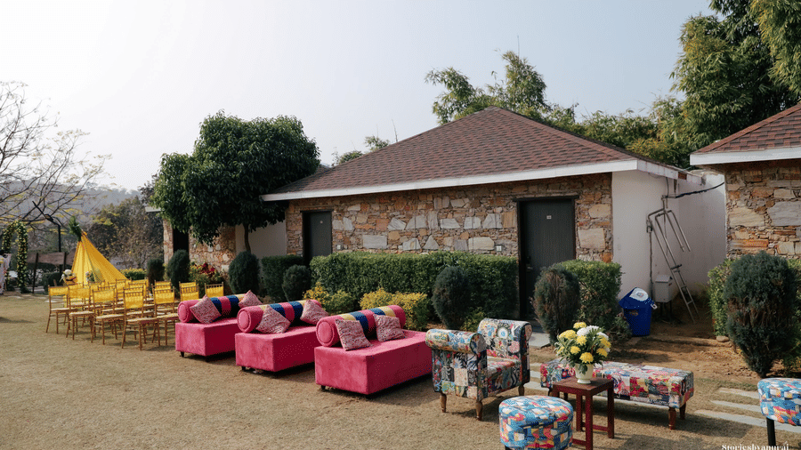 Outdoor event setup at Valley By Grassfield, featuring a small building, chairs, and various decorations in a daytime setting.