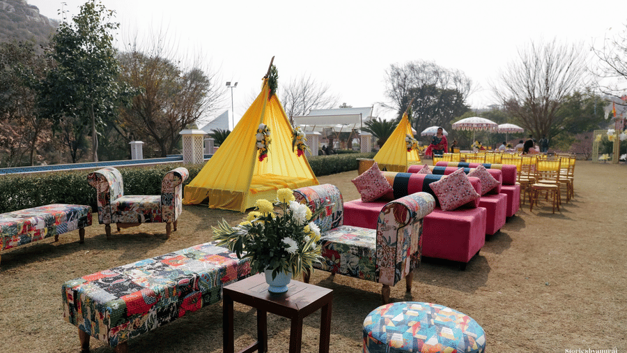 Canopied outdoor seating with tables and decor for celebrations at Valley by Grassfield, a wedding resort in Jaipur.